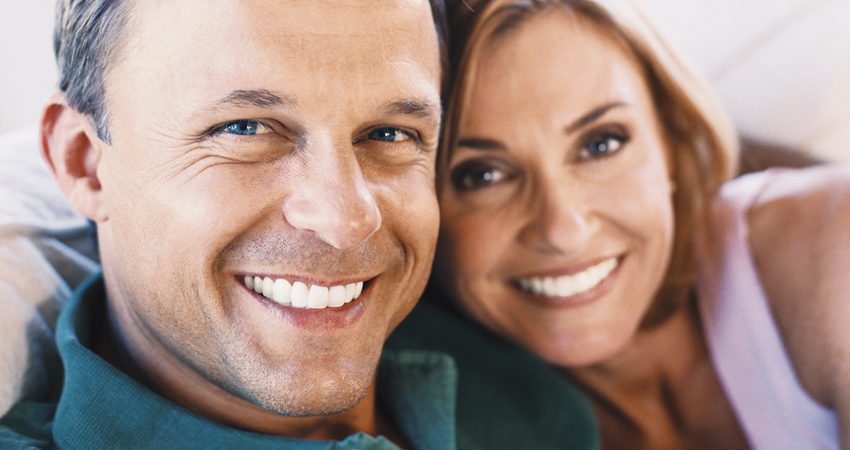 Middle-aged couple smiles after getting an oral cancer screening